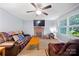 Cozy living room featuring a brick fireplace, leather seating, and a ceiling fan with overhead lighting at 653 Turner St, Mooresville, NC 28115
