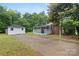 Home featuring a storage building, an extended driveway, and a covered back porch with white railings at 653 Turner St, Mooresville, NC 28115