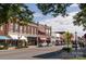 Street view displaying brick buildings with awnings and shops, complemented by a crosswalk sign and American flags at 653 Turner St, Mooresville, NC 28115