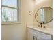 Stylish bathroom featuring a white vanity with a quartz countertop and an oval mirror at 709 Catawba St, Lincolnton, NC 28092