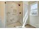 Bright bathroom showcasing a modern shower with marble tiling, glass enclosure, and a window for natural light at 709 Catawba St, Lincolnton, NC 28092