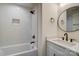 Bathroom with a combined shower and tub featuring modern fixtures and a stylish vanity with circular mirror at 709 Catawba St, Lincolnton, NC 28092