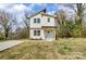 Charming two-story home featuring a light yellow exterior with a striking blue front door and well-manicured lawn at 709 Catawba St, Lincolnton, NC 28092