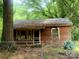 Rustic exterior of a weathered home surrounded by lush greenery and mature trees at 711 East Dr, Cherryville, NC 28021