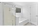 Well-lit bathroom featuring a glass-enclosed shower and a separate soaking tub at 7212 Ravanna Dr, Charlotte, NC 28213