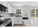 Bright kitchen with white cabinets, island, stainless steel appliances, and sleek countertops at 7212 Ravanna Dr, Charlotte, NC 28213