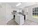 Well-lit kitchen with island, white cabinets, stainless steel appliances, and natural light at 7212 Ravanna Dr, Charlotte, NC 28213