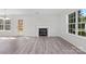 Bright living room with fireplace, wood-look flooring, and access to backyard at 7212 Ravanna Dr, Charlotte, NC 28213