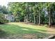 Spacious backyard with lush lawn, mature trees, and a shed offering plenty of outdoor living space at 7691 Red Robin Trl, Denver, NC 28037