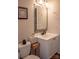 Neat bathroom featuring a toilet, vanity with sink, mirror, and updated fixtures at 7691 Red Robin Trl, Denver, NC 28037