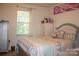 Cozy bedroom with comfortable bed, dresser, window with valance, and wall decor at 7691 Red Robin Trl, Denver, NC 28037