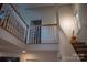 Upper staircase landing with a view of the living area and ample natural light at 7691 Red Robin Trl, Denver, NC 28037