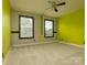 This bedroom features neutral carpet, two windows, and two-toned walls at 9913 Hazelview Dr, Charlotte, NC 28277