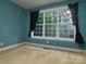 This bedroom features a large window allowing for natural light and neutral carpet at 9913 Hazelview Dr, Charlotte, NC 28277