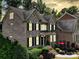 Handsome brick house with black shutters, complemented by a red patio umbrella and lush landscaping at 9913 Hazelview Dr, Charlotte, NC 28277