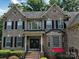 Charming brick two-story home featuring black shutters, arched windows and manicured landscaping at 9913 Hazelview Dr, Charlotte, NC 28277
