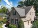 Side view of a brick home with an attached two-car garage and mature trees in the background at 9913 Hazelview Dr, Charlotte, NC 28277