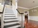 Elegant foyer with staircase, gleaming hardwood floors, white wainscoting and a chandelier at 9913 Hazelview Dr, Charlotte, NC 28277