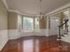 Bright living room featuring hardwood floors, elegant trim, and large windows with a chandelier at 9913 Hazelview Dr, Charlotte, NC 28277