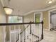 Carpeted staircase featuring white railings and large chandelier at 9913 Hazelview Dr, Charlotte, NC 28277
