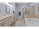 Bathroom featuring a soaking tub, glass-enclosed shower, and vanity at 10206 Linksland Dr, Huntersville, NC 28078