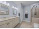 Bathroom featuring a soaking tub, glass-enclosed shower, and double vanity at 10206 Linksland Dr, Huntersville, NC 28078