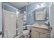 Bathroom featuring a glass shower, beige vanity, and updated lighting at 10206 Linksland Dr, Huntersville, NC 28078