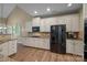 Bright kitchen with white cabinets, granite countertops, and stainless steel refrigerator at 10206 Linksland Dr, Huntersville, NC 28078