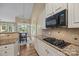 Kitchen area with black microwave and stove top oven with granite counter tops at 10206 Linksland Dr, Huntersville, NC 28078