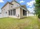 Enclosed back porch extends into a private yard with green grass, white fence, and exterior HVAC unit at 1033 Crawford Dr, Lancaster, SC 29720