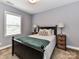 Bedroom showcasing a cozy queen bed with wood accents, side tables, and lamps at 10515 Royal Winchester Dr, Charlotte, NC 28277