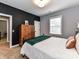 Bedroom with white and gray walls features a wooden wardrobe with a green blanket at 10515 Royal Winchester Dr, Charlotte, NC 28277
