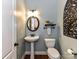 Quaint powder room with pedestal sink, round mirror, and modern fixtures at 10515 Royal Winchester Dr, Charlotte, NC 28277