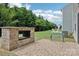 Landscaped backyard including an outdoor fireplace, patio, bench, and green lawn at 107 Sequoia St, Mooresville, NC 28117
