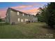 Large backyard featuring a stone fireplace, with green grass and trees at 107 Sequoia St, Mooresville, NC 28117