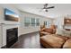Comfortable living room with fireplace, ceiling fan, and leather sofa with hardwood flooring at 107 Sequoia St, Mooresville, NC 28117
