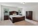 Spacious main bedroom with carpet, two windows, and dark wood furniture set at 107 Sequoia St, Mooresville, NC 28117