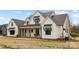 Charming two-story farmhouse with a covered porch, black window accents and well manicured landscaping at 111 Monbo Meadows Ln, Statesville, NC 28677