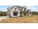 Charming two-story farmhouse with a three car garage, black window accents and well manicured landscaping at 111 Monbo Meadows Ln, Statesville, NC 28677