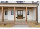 Inviting front entrance with double glass doors, wood columns, and potted plants at 111 Monbo Meadows Ln, Statesville, NC 28677
