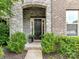 Stone archway frames the front door with manicured shrubs adding curb appeal at 121 Enclave Meadows Ln, Matthews, NC 28104