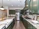 Stylish kitchen with dark green cabinetry, marble counters, and stainless steel appliances at 121 Enclave Meadows Ln, Matthews, NC 28104