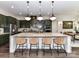 Gourmet kitchen with a large marble island, pendant lighting, and seating for four at 121 Enclave Meadows Ln, Matthews, NC 28104
