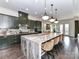 Open-concept kitchen featuring dark green cabinets, marble countertops, and stainless steel appliances at 121 Enclave Meadows Ln, Matthews, NC 28104