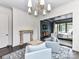 Inviting living room with a decorative fireplace and an open doorway to the primary bedroom at 121 Enclave Meadows Ln, Matthews, NC 28104
