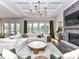 Bright living room featuring a stone fireplace, coffered ceiling, and large sectional sofa at 121 Enclave Meadows Ln, Matthews, NC 28104