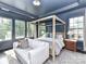 Elegant bedroom with a decorative tray ceiling, large windows, and a four-poster bed at 121 Enclave Meadows Ln, Matthews, NC 28104
