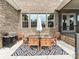Covered brick patio with a dining set, grill, and a view of the backyard at 121 Enclave Meadows Ln, Matthews, NC 28104
