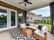 Comfortable covered patio with wicker seating and a decorative rug, perfect for outdoor living at 121 Enclave Meadows Ln, Matthews, NC 28104