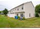 Private backyard oasis with a white fence, green lawn, and vibrant flower beds, perfect for outdoor entertaining at 12222 Stratfield Place Cir, Pineville, NC 28134